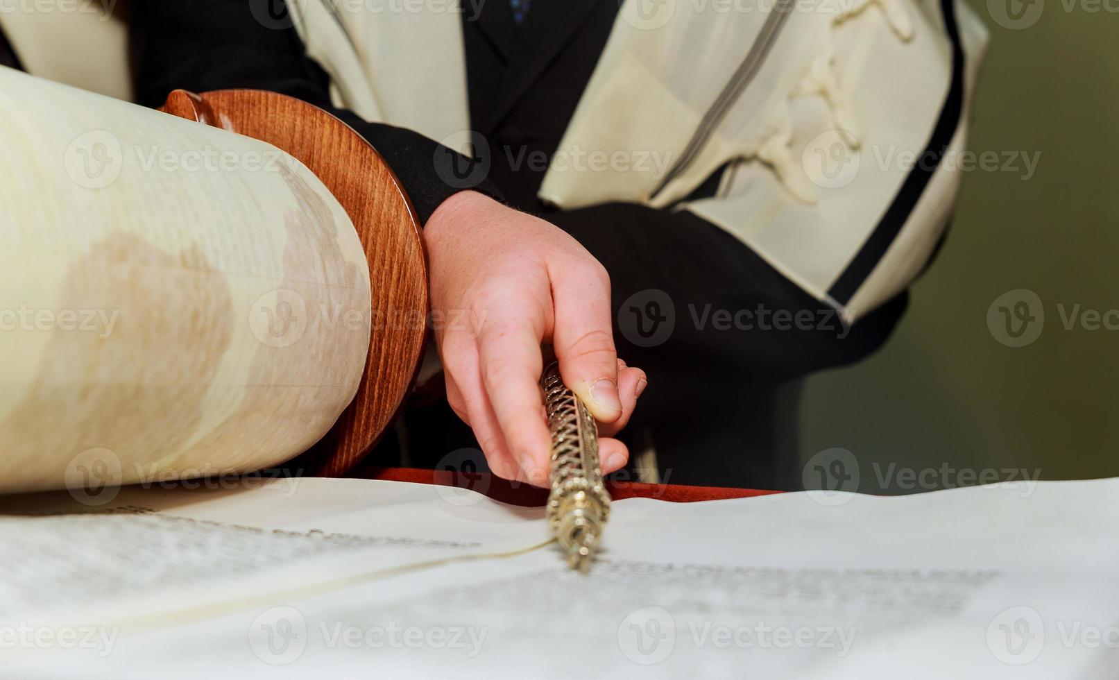 Hand of boy reading the Jewish Torah at Bar Mitzvah photo