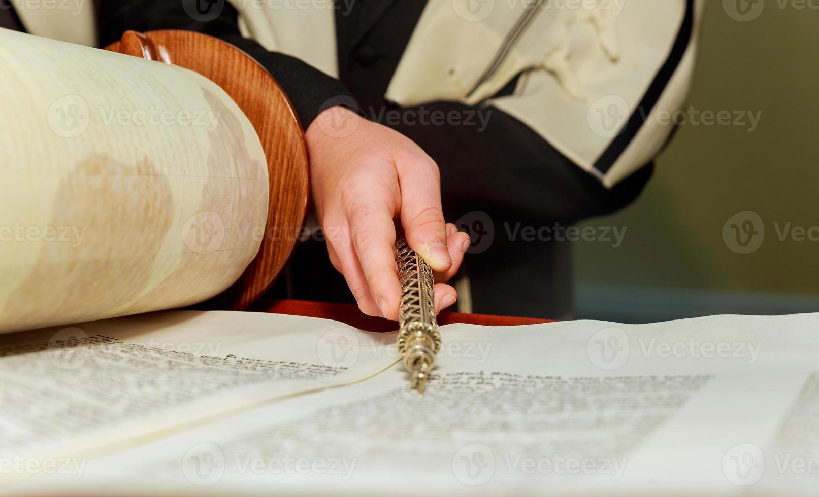 mano de niño leyendo la torá judía en bar mitzvah foto