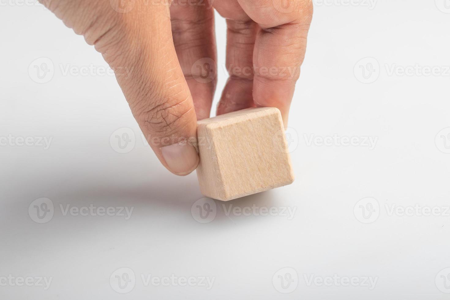Hand picking up empty wooden square blocks on white background. photo