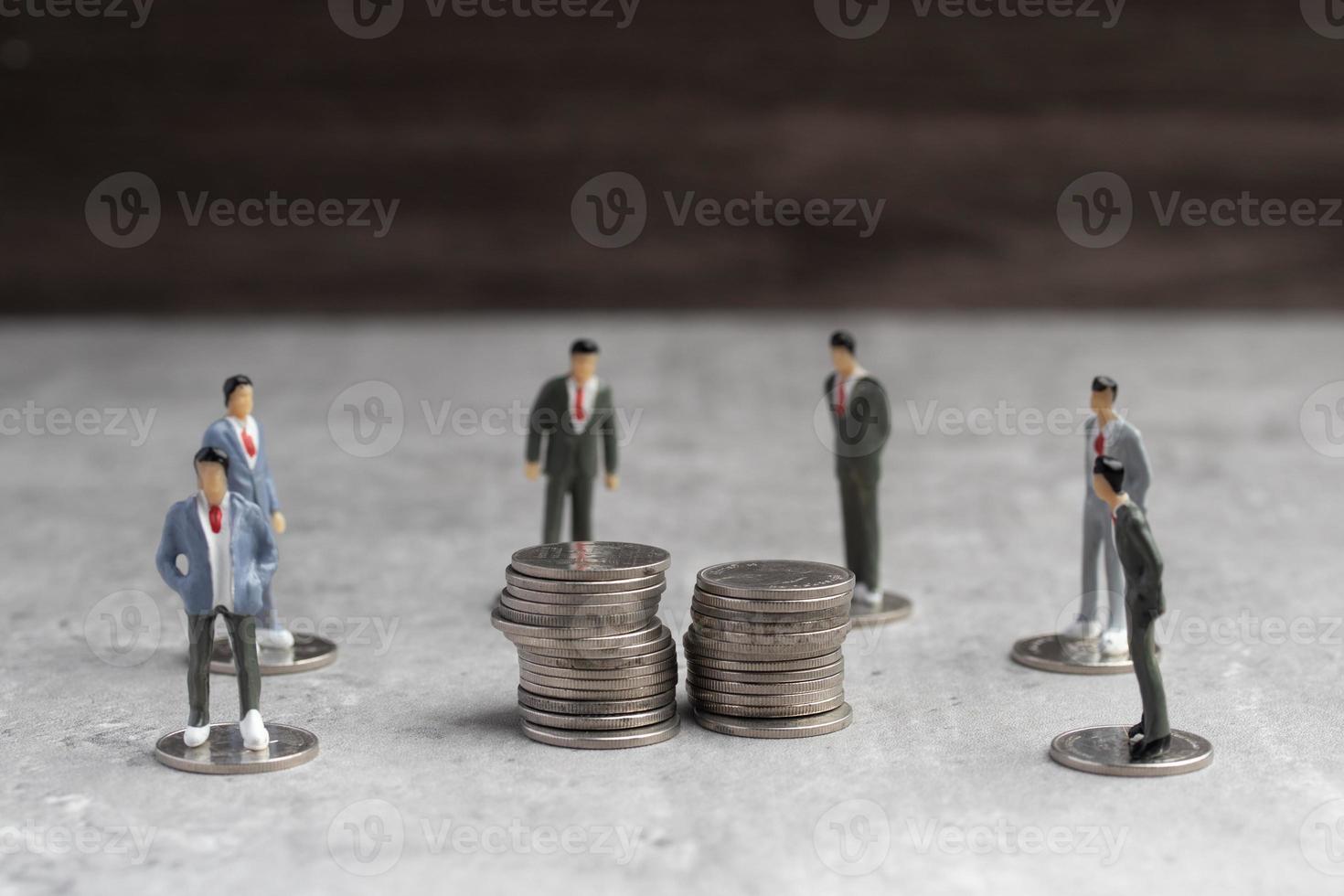 miniatura personas en pie alrededor monedas, negocio hombre sacudida manos durante un reunión, éxito, relación comercial, saludo y compañero concepto. foto