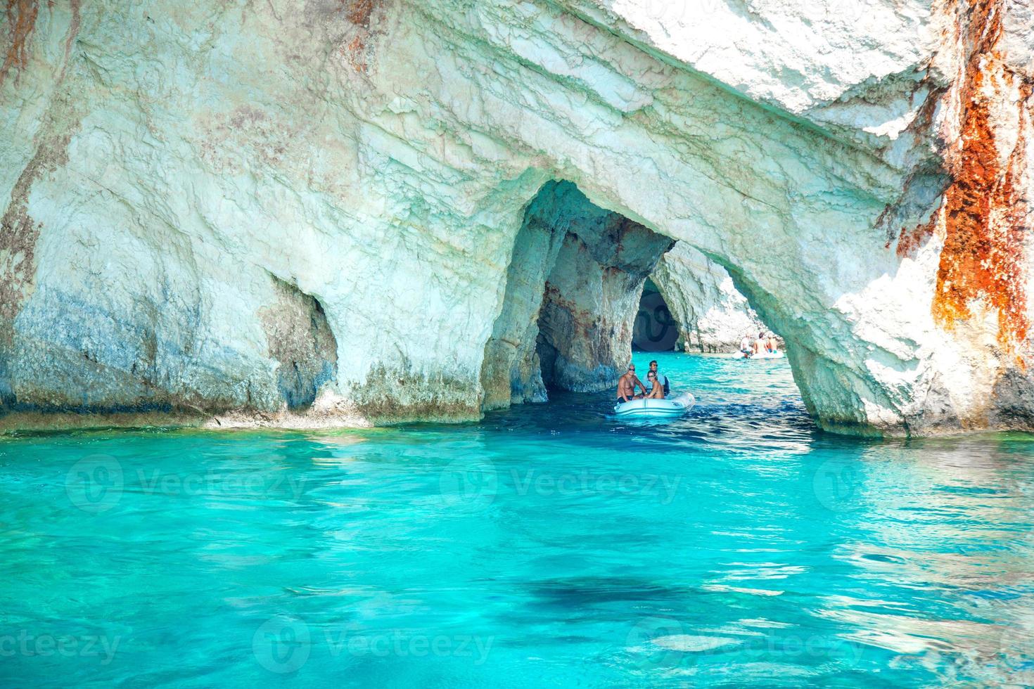 Boat of tourists glide through the Blue Caves, Kefalonia, Greece photo