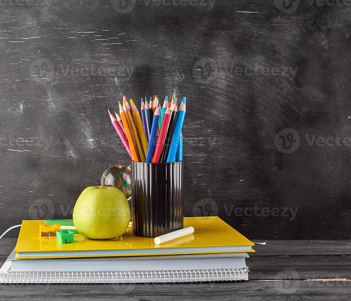 ripe green apple on a stack of notebooks photo