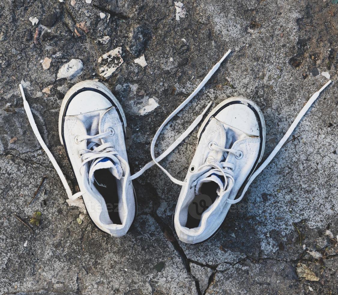 pair of old worn white sneakers with laces photo