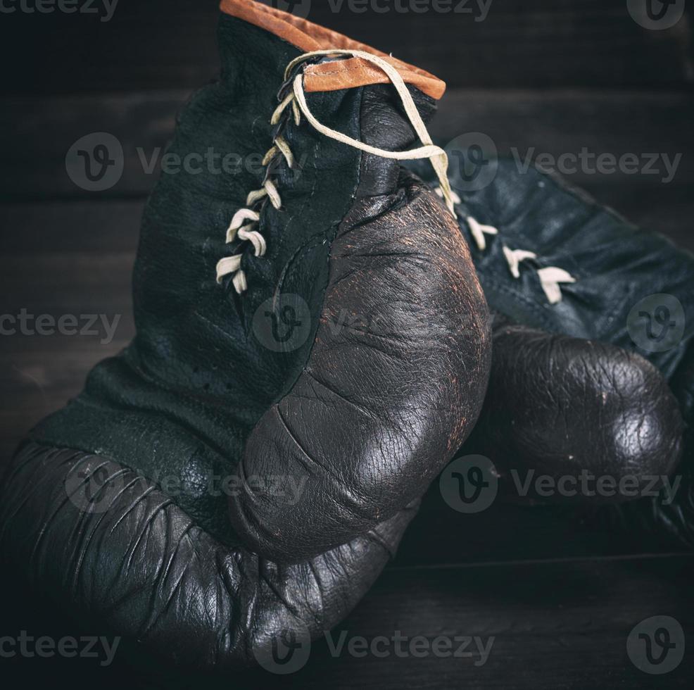 pair of very old shabby black leather boxing gloves photo