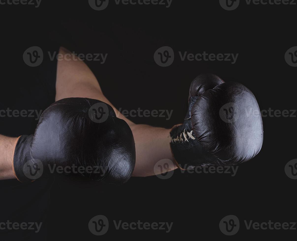 men's hands are wearing old leather  boxing gloves photo