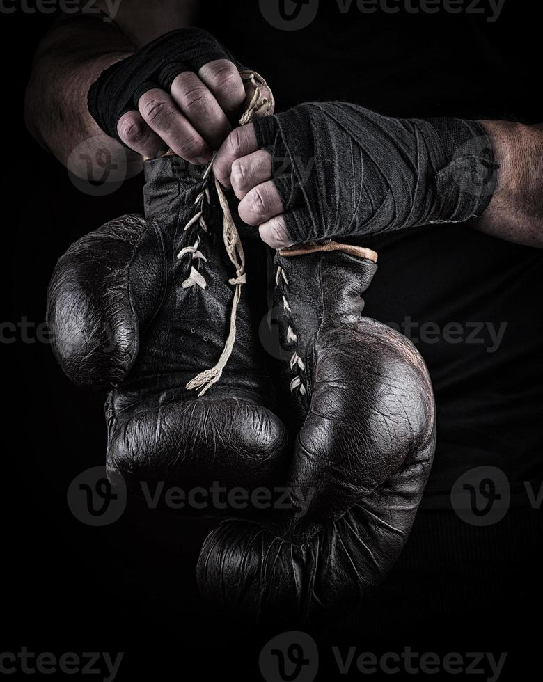 very old boxing sports gloves in men's hands photo