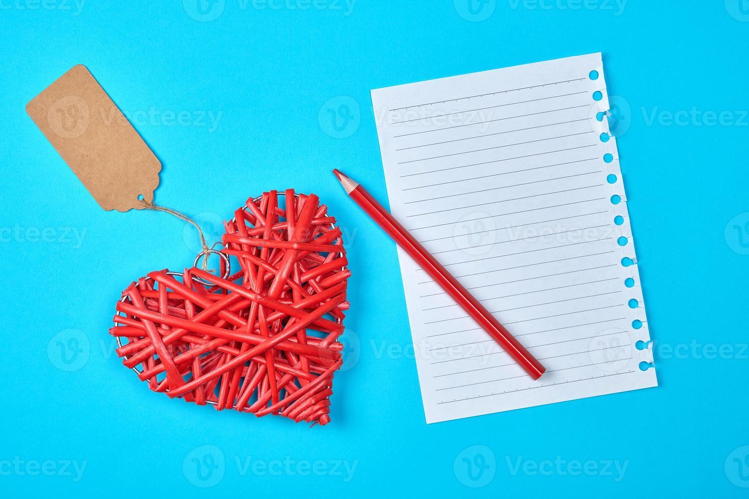 wooden wicker red heart and an empty white sheet of notepad photo
