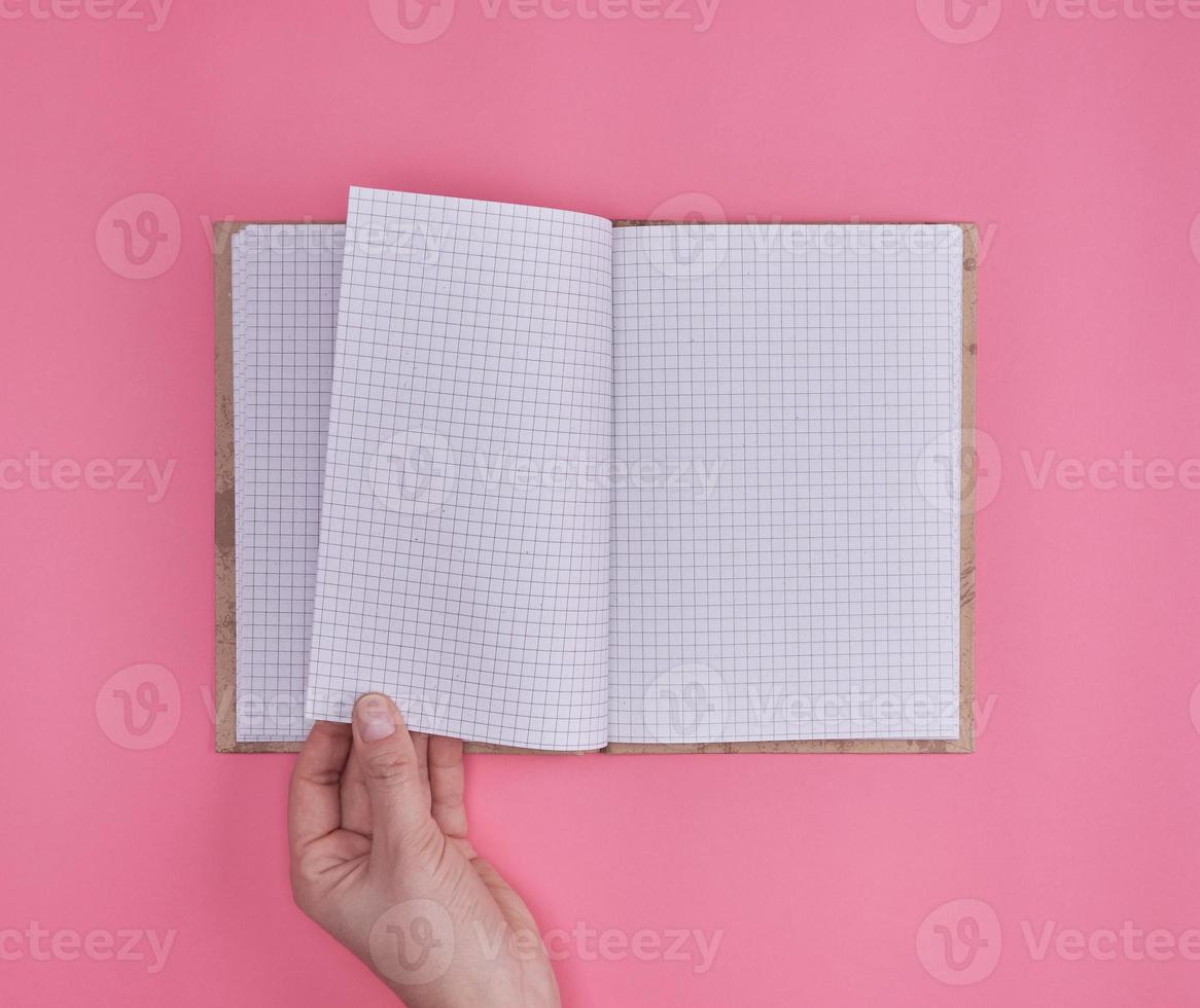 open notebook in a cell and a female hand photo