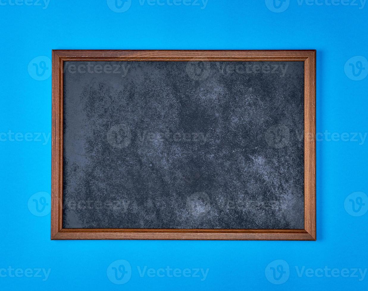 wooden empty chalk board on a blue background photo