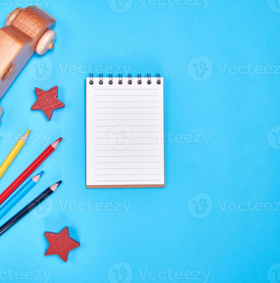 notebook with blank white sheets in line and multicolored wooden pencils photo