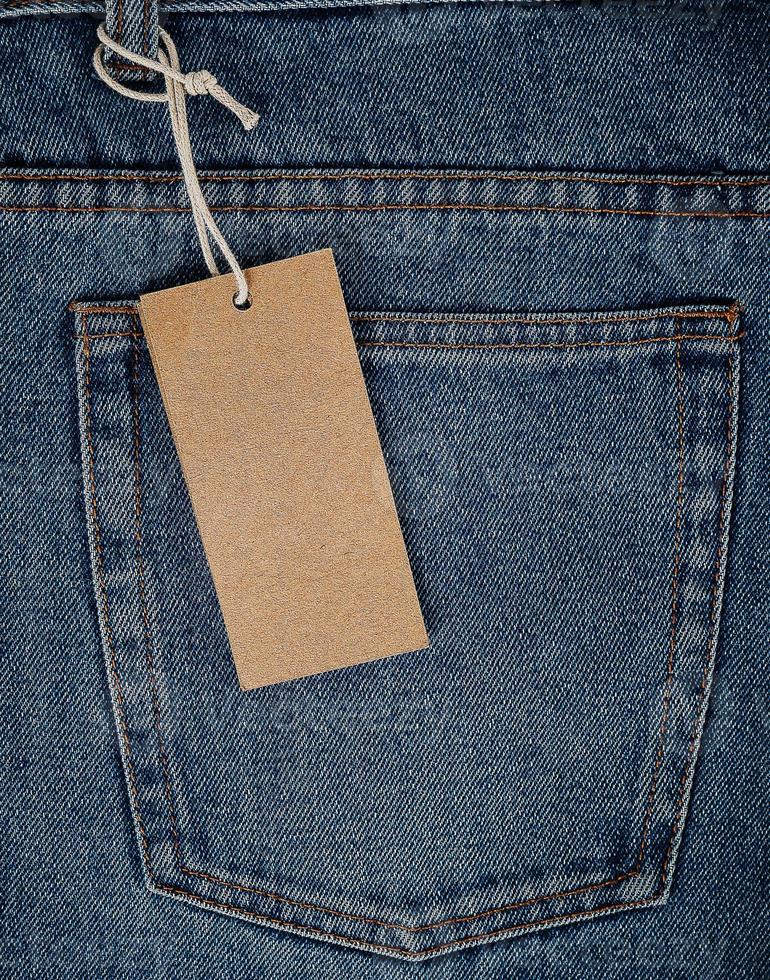 empty rectangular brown paper tag on blue jeans photo