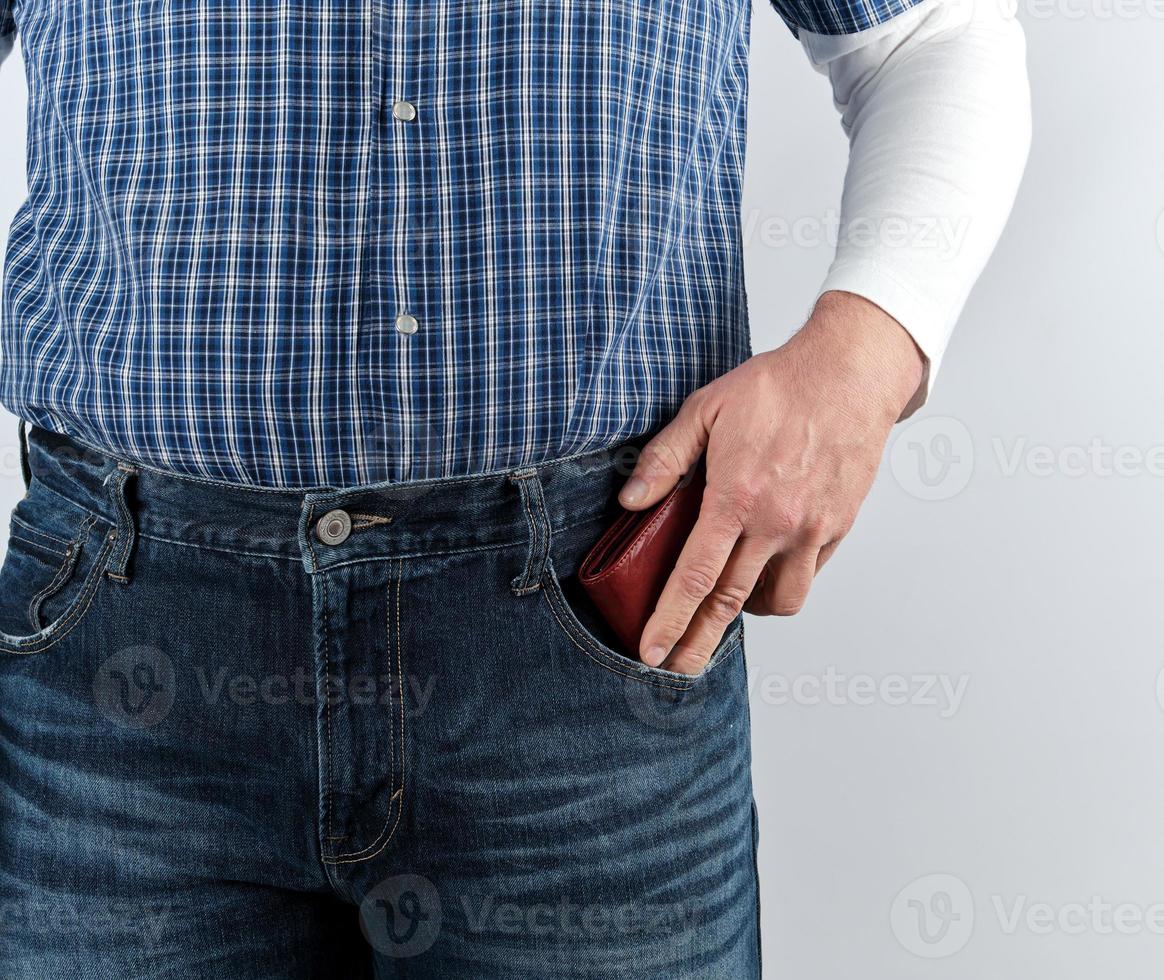man in blue jeans and a plaid shirt shoves photo