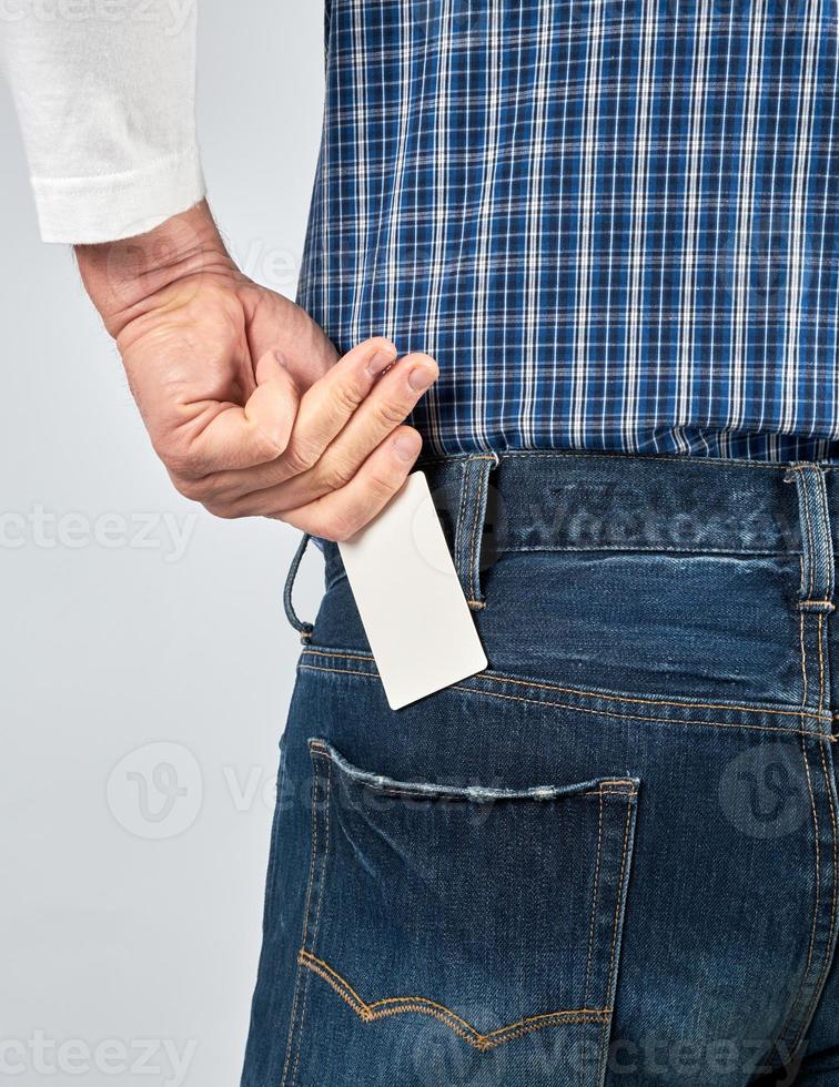 man puts an empty white paper business card photo