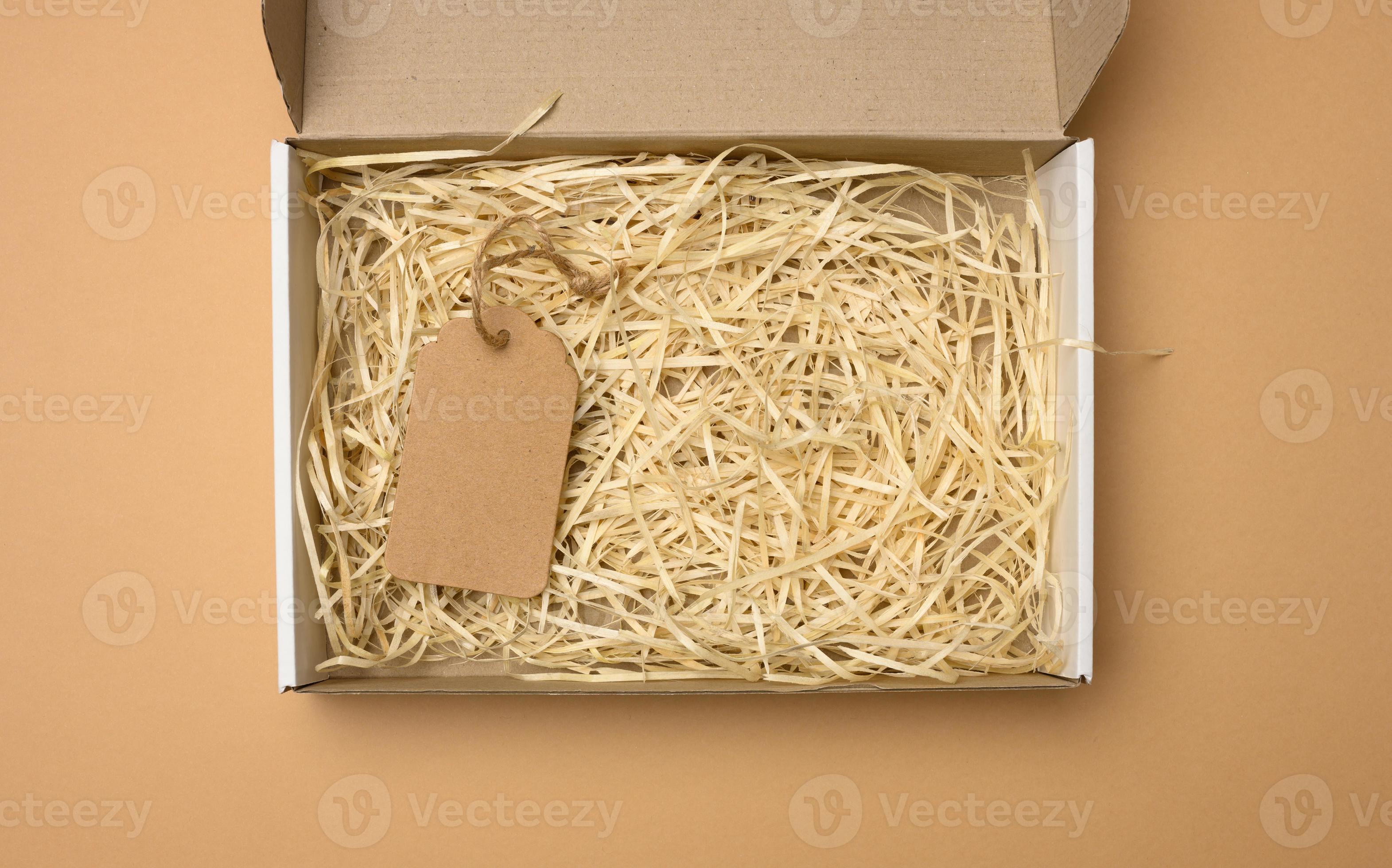 empty rectangular open corrugated paper box with sawdust inside