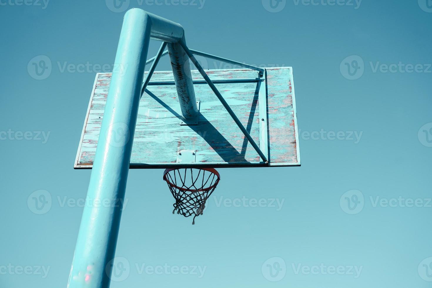 old abandoned street basketball hoop and blue sky background photo