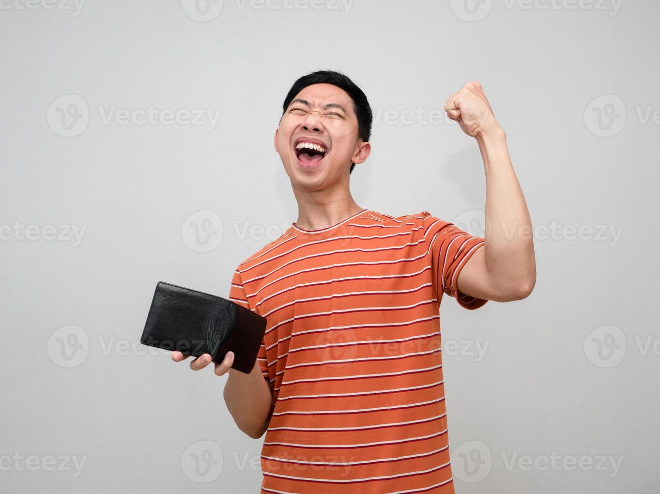 Positive man orange striped shirt holding wallet happy with earn money,Rich man holding wallet feels success photo