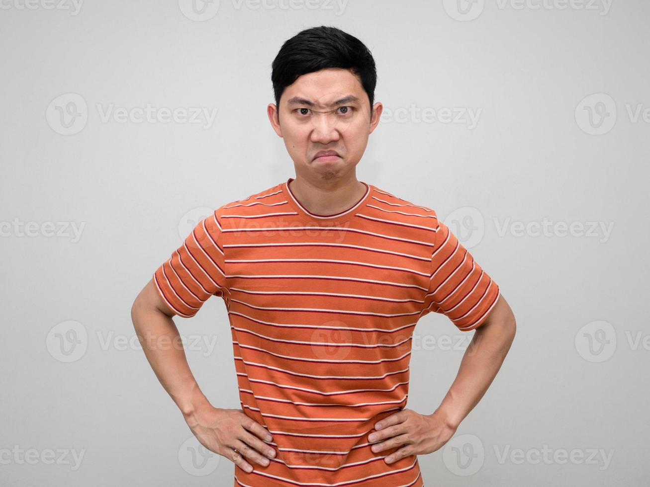Asian man striped shirt stand hand at waist feels angry looking at you isolated photo