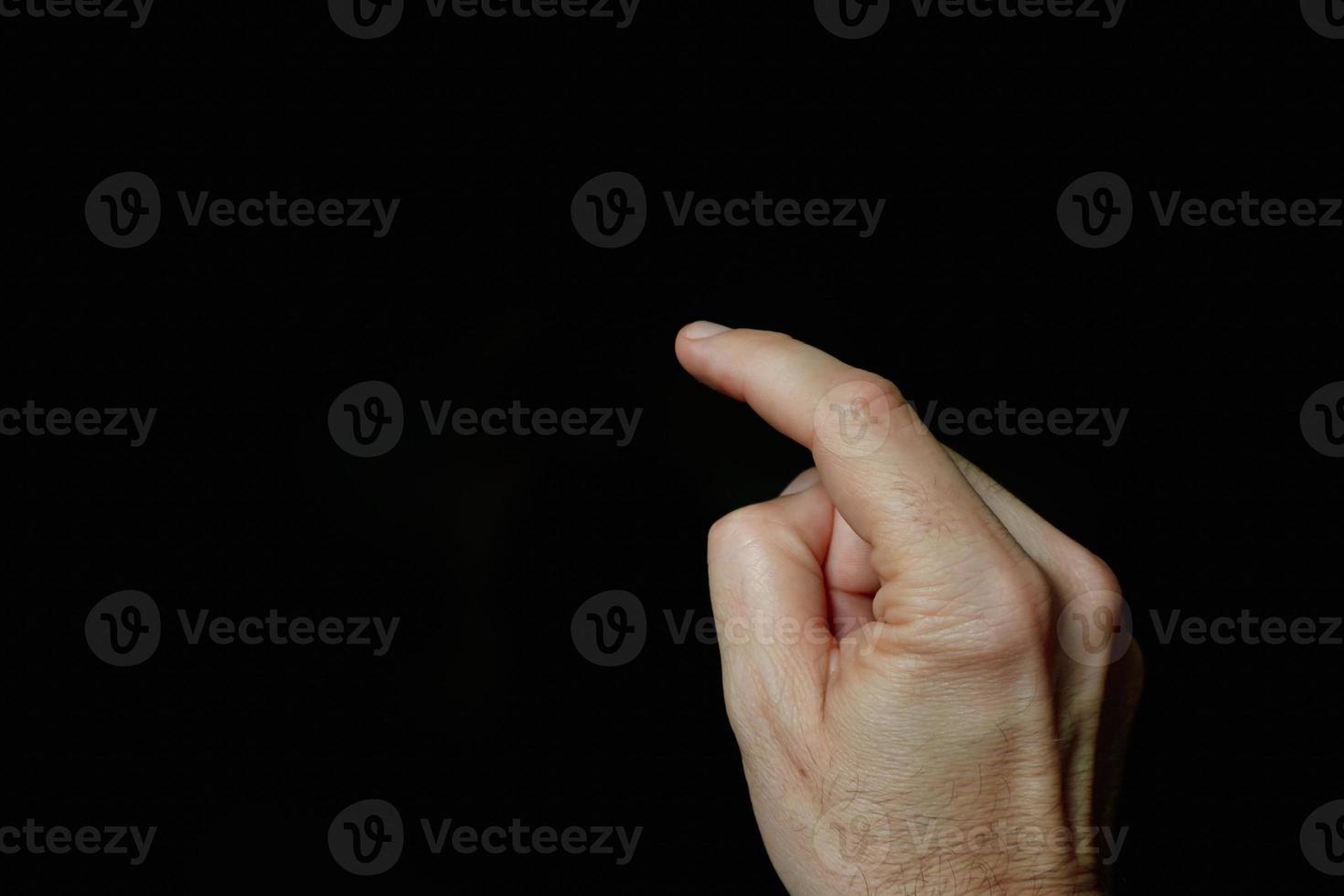 index finger pointing at the screen, black background photo