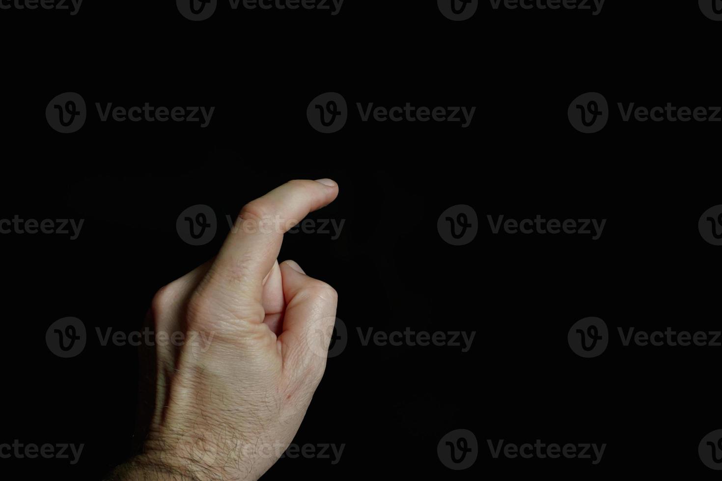index finger pointing at the screen, black background photo