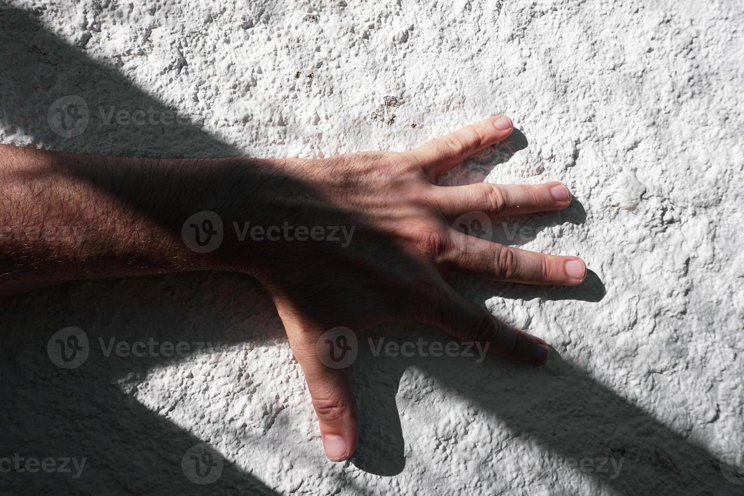 hand on the white wall gesturing with shadows photo