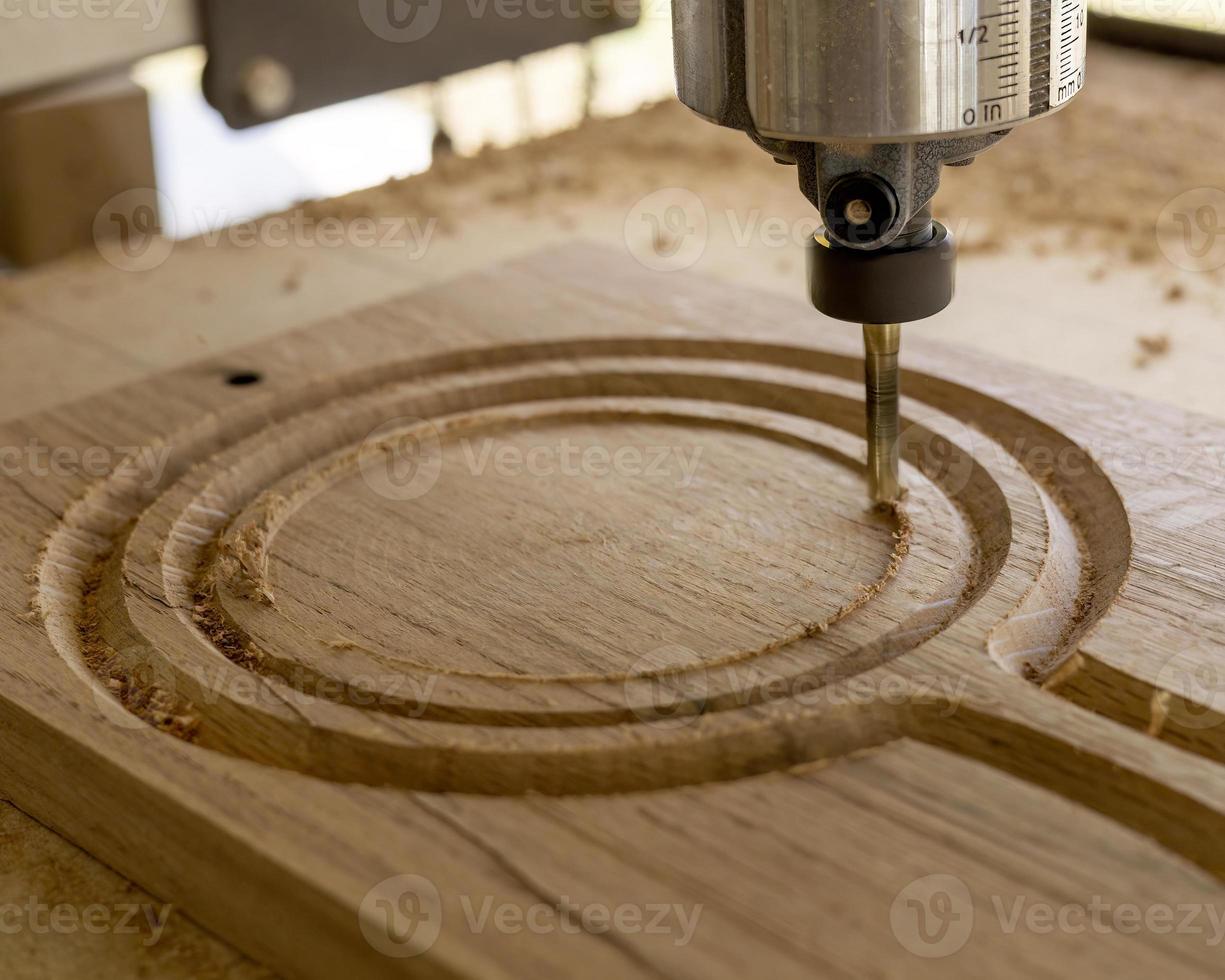 A CNC machine routing a circle on an oak wood board 19764429 Stock
