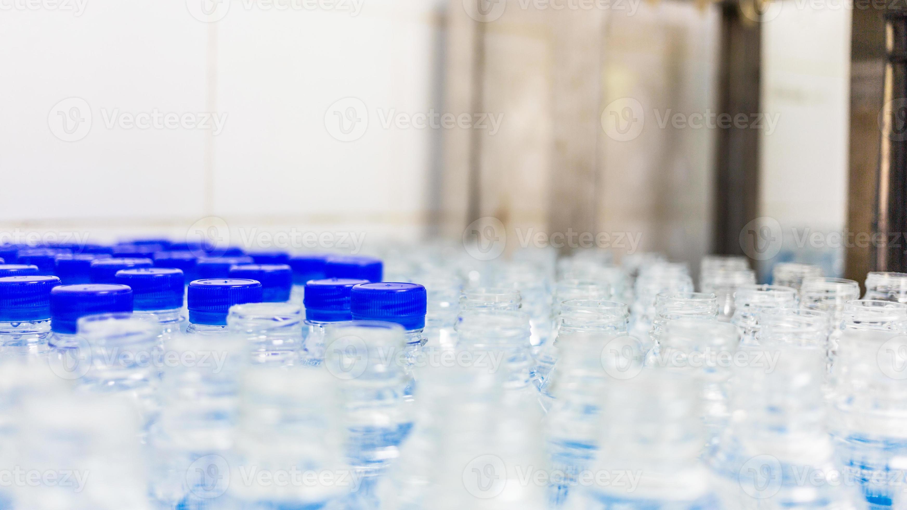 Lots of water bottles. Bottles with blue caps. Bottling plantWater