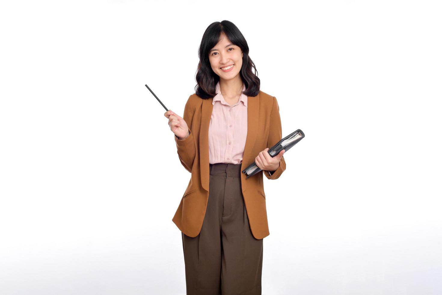 Happy young asian business woman holding notepad and pointing pencil up isolated on white background photo