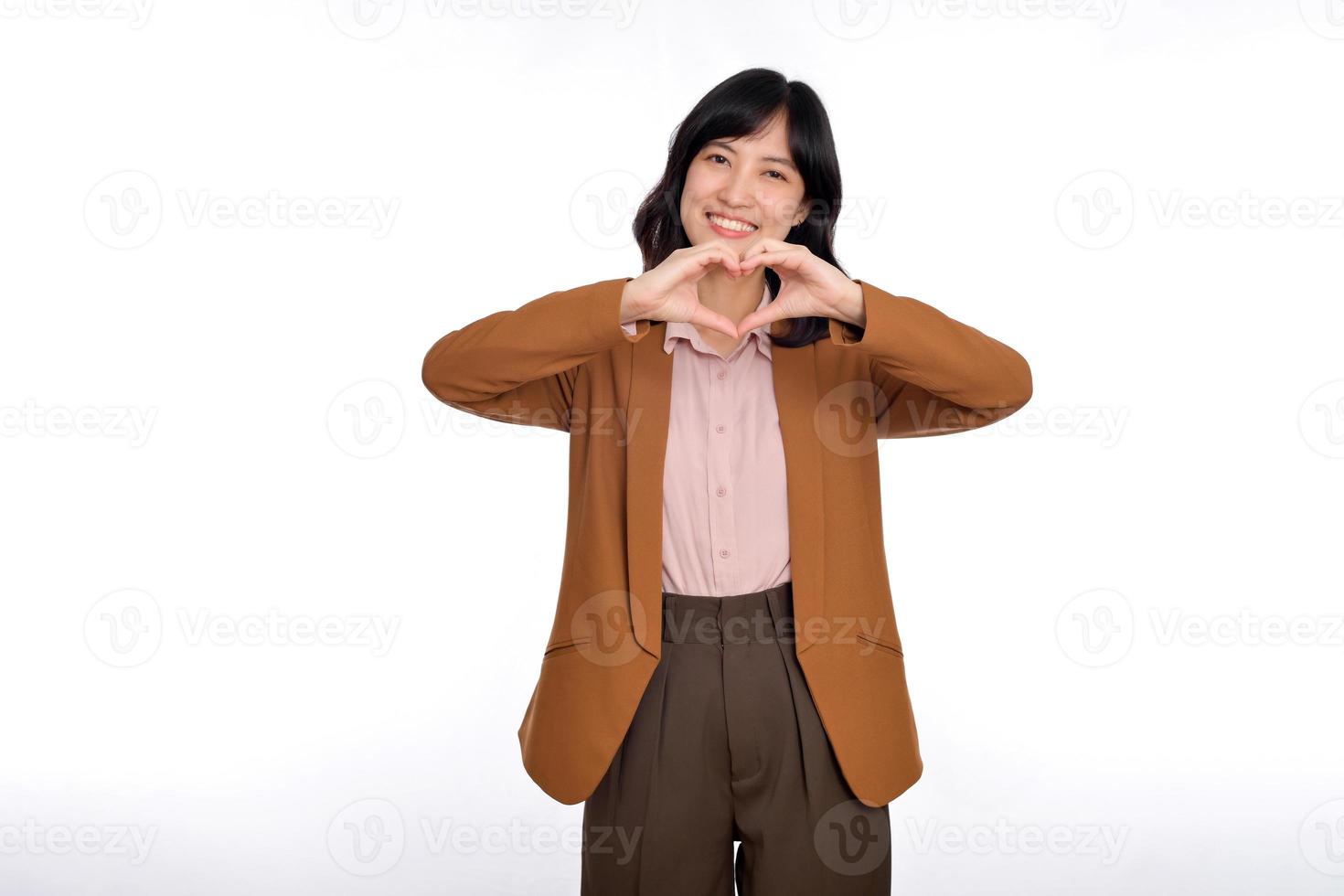Young Asian woman showing hand heart sign isolated on white background, Spreading love and happiness concept photo