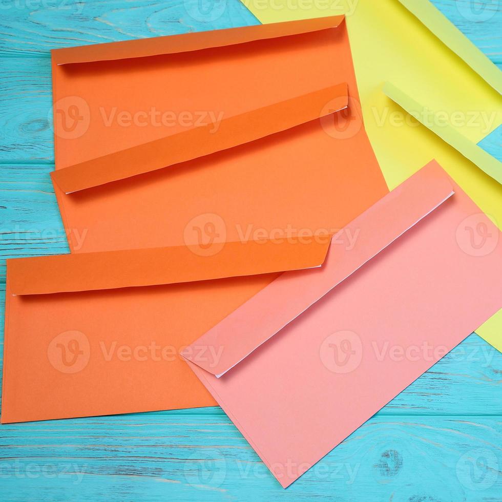 Group of colorful envelopes on wooden table, mock up photo