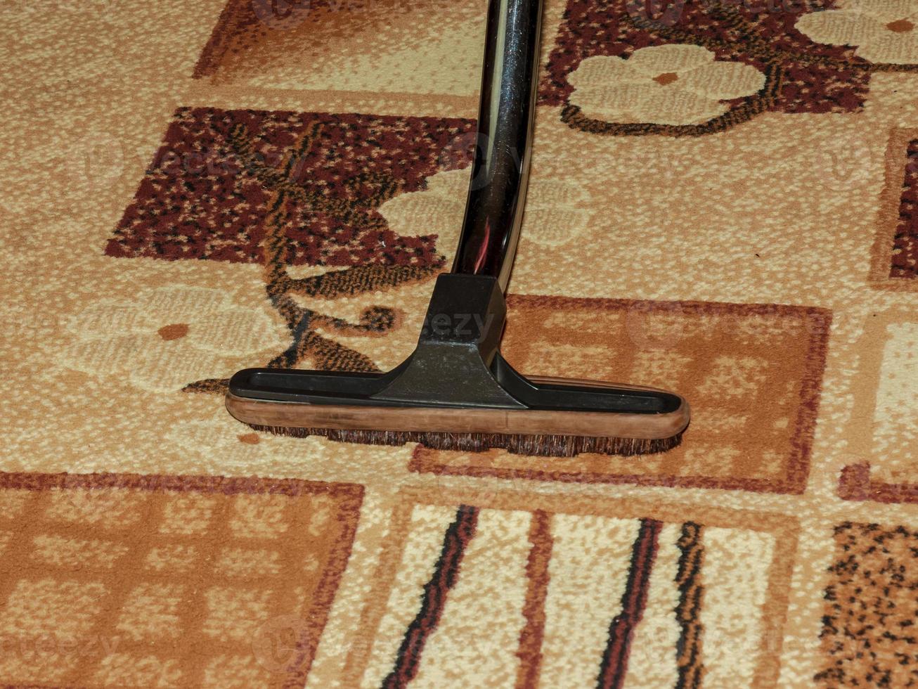 The head of a modern vacuum cleaner against the background of a carpet. Close. photo