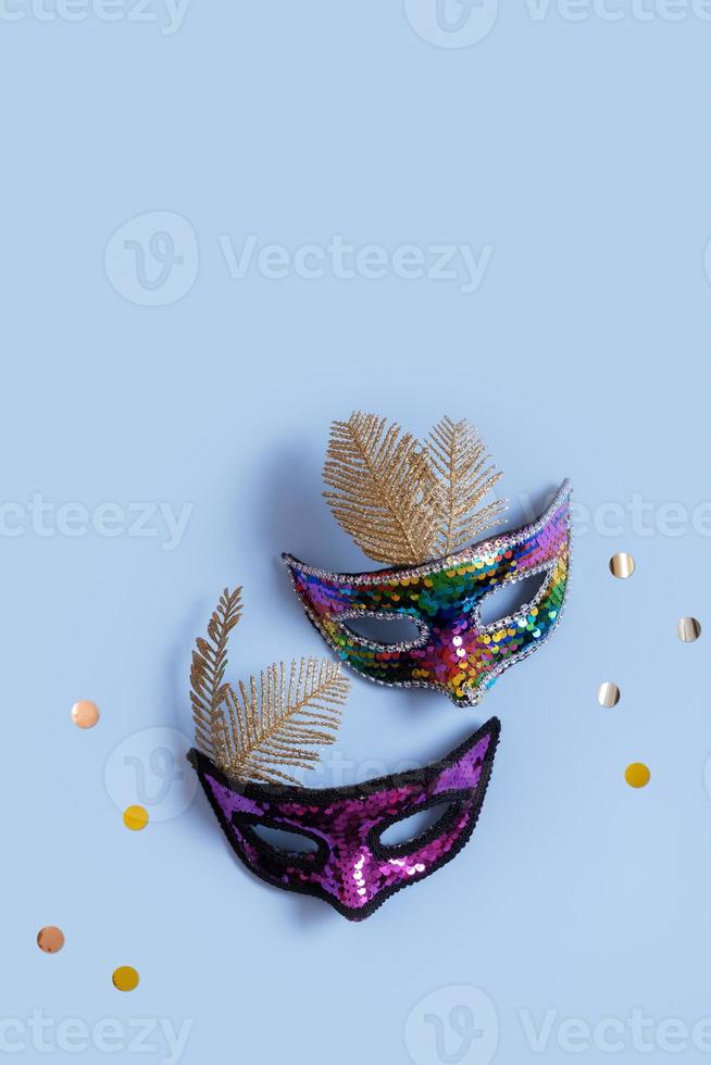 Festive face masks for masquerade or carnival celebration on colored background. Blank greeting card or invitation photo