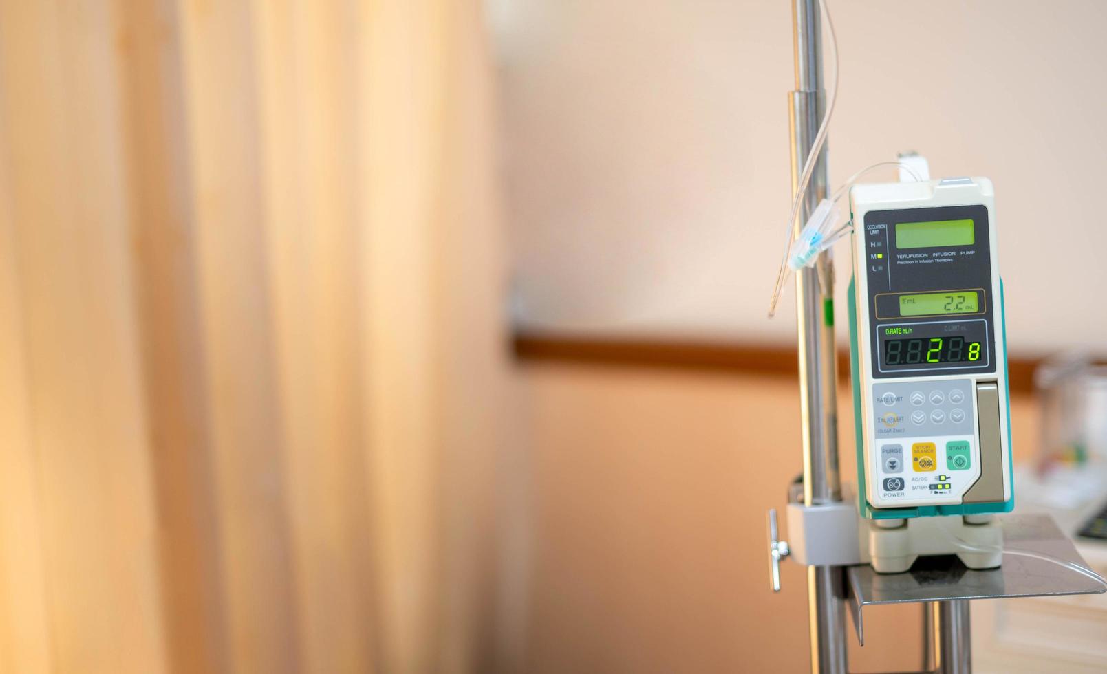 Modern automatic Infusion pump for control infuses fluids medication or nutrients sodium chloride saline solution fluid hanging at the IV pole in the hospital. photo