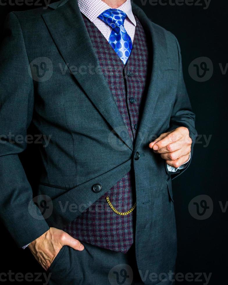 retrato de Caballero en gris traje en pie esmeradamente en negro antecedentes. Clásico estilo y retro moda. foto