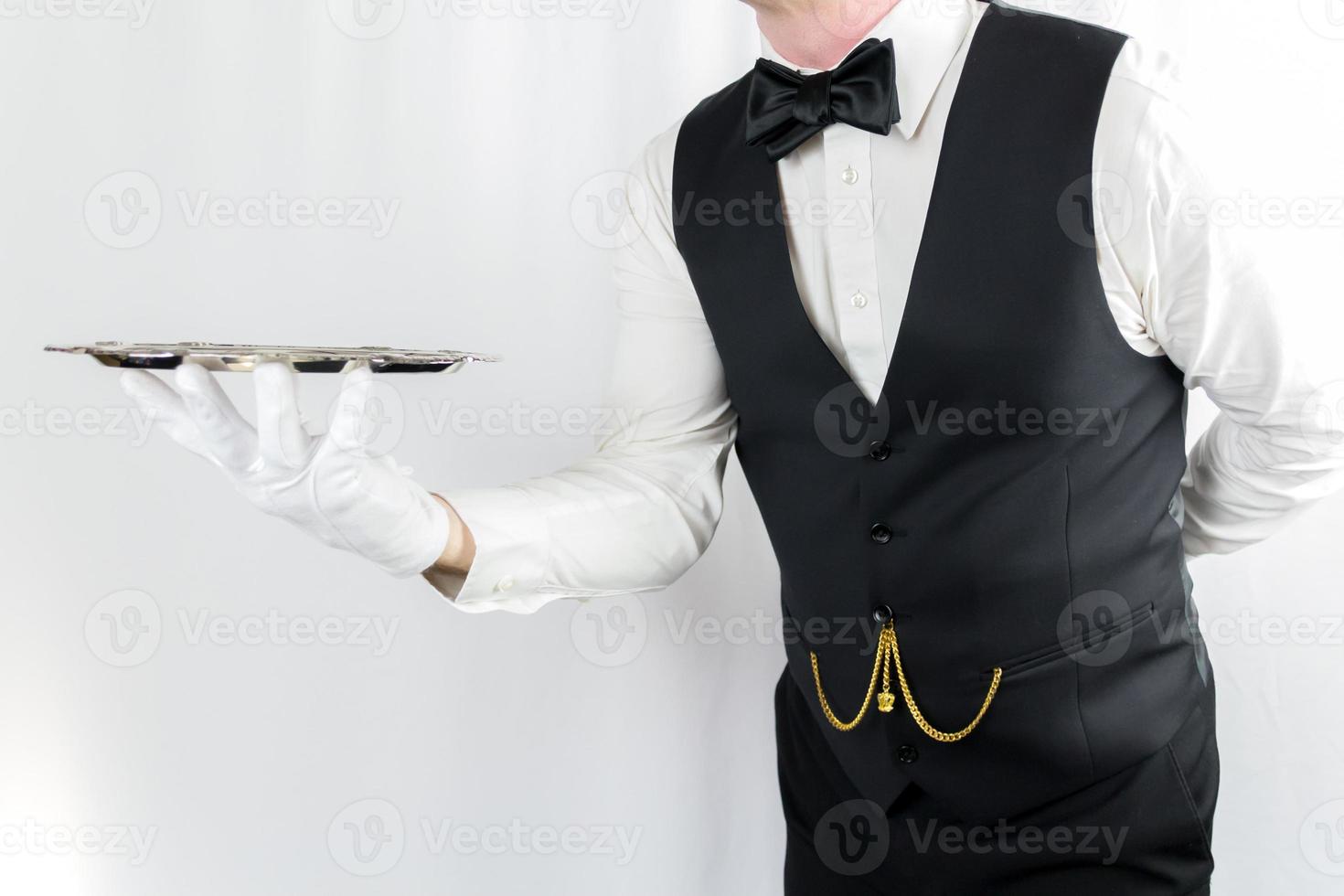 Portrait of Waiter or Butler in White Gloves Holding Silver Tray on White Background. Concept of Service Industry and Professional Hospitality. photo