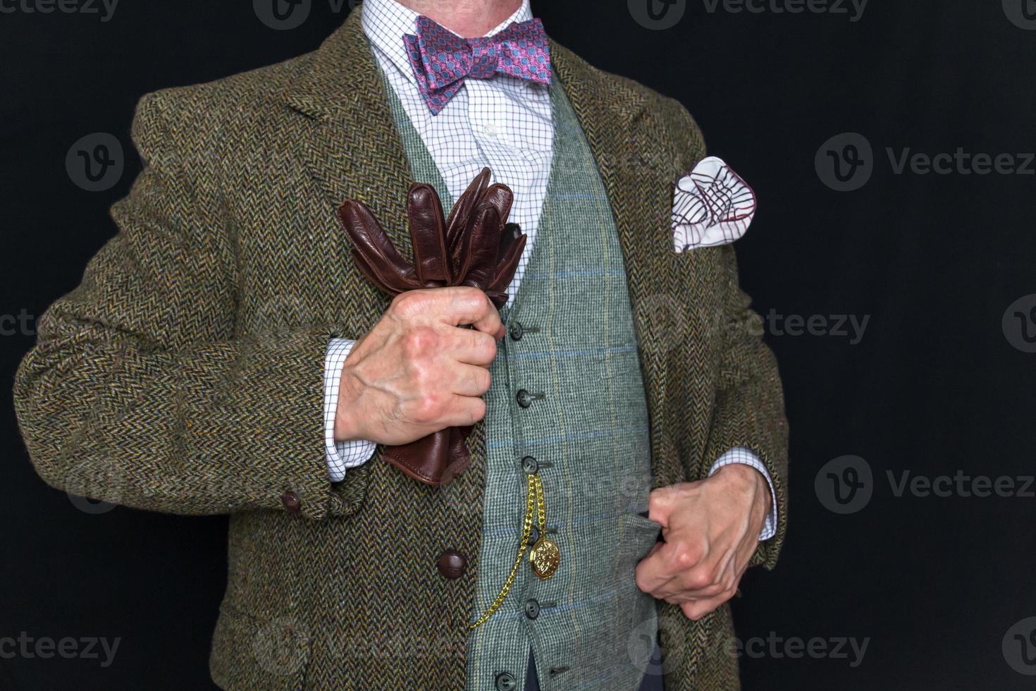 retrato de Caballero en tweed traje en negro antecedentes participación cuero guantes. Clásico estilo y retro moda. clásico Inglés Caballero. foto