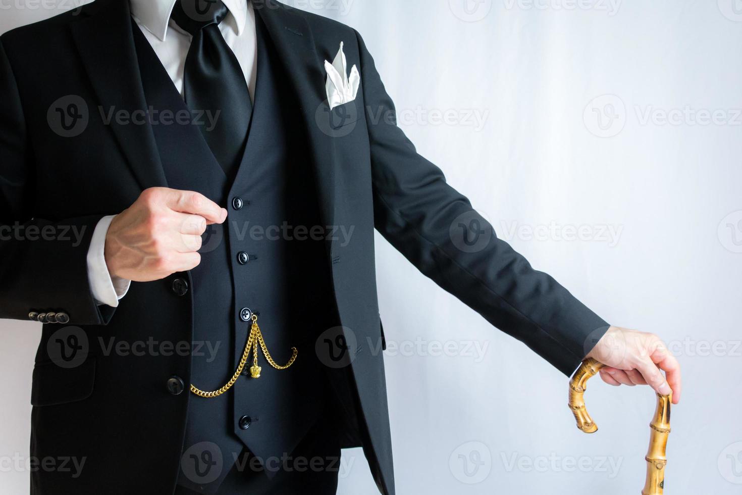 Portrait of Businessman in Dark Suit on White Background Leaning Serenely on Umbrella. Vintage Fashion and Retro Style. Elegant English Gentleman. photo