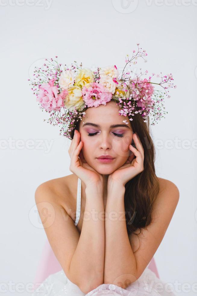 retrato de hermosa novia con flor guirnalda en su cabeza a blanco antecedentes foto