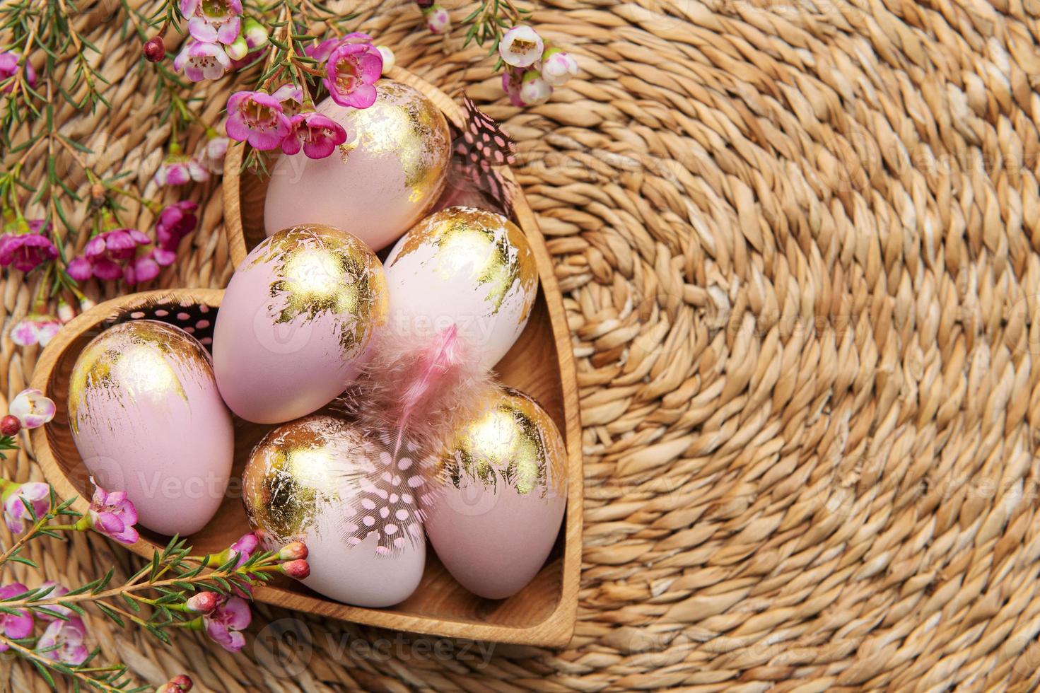 Pascua de Resurrección decoración. Pascua de Resurrección huevos pintado en oro en un en forma de corazon de madera bol. foto