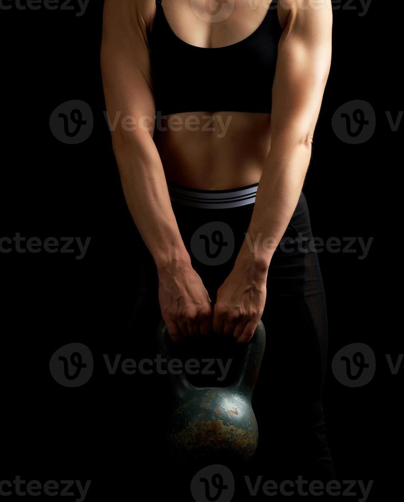 girl of athletic appearance holds an iron kettlebell photo