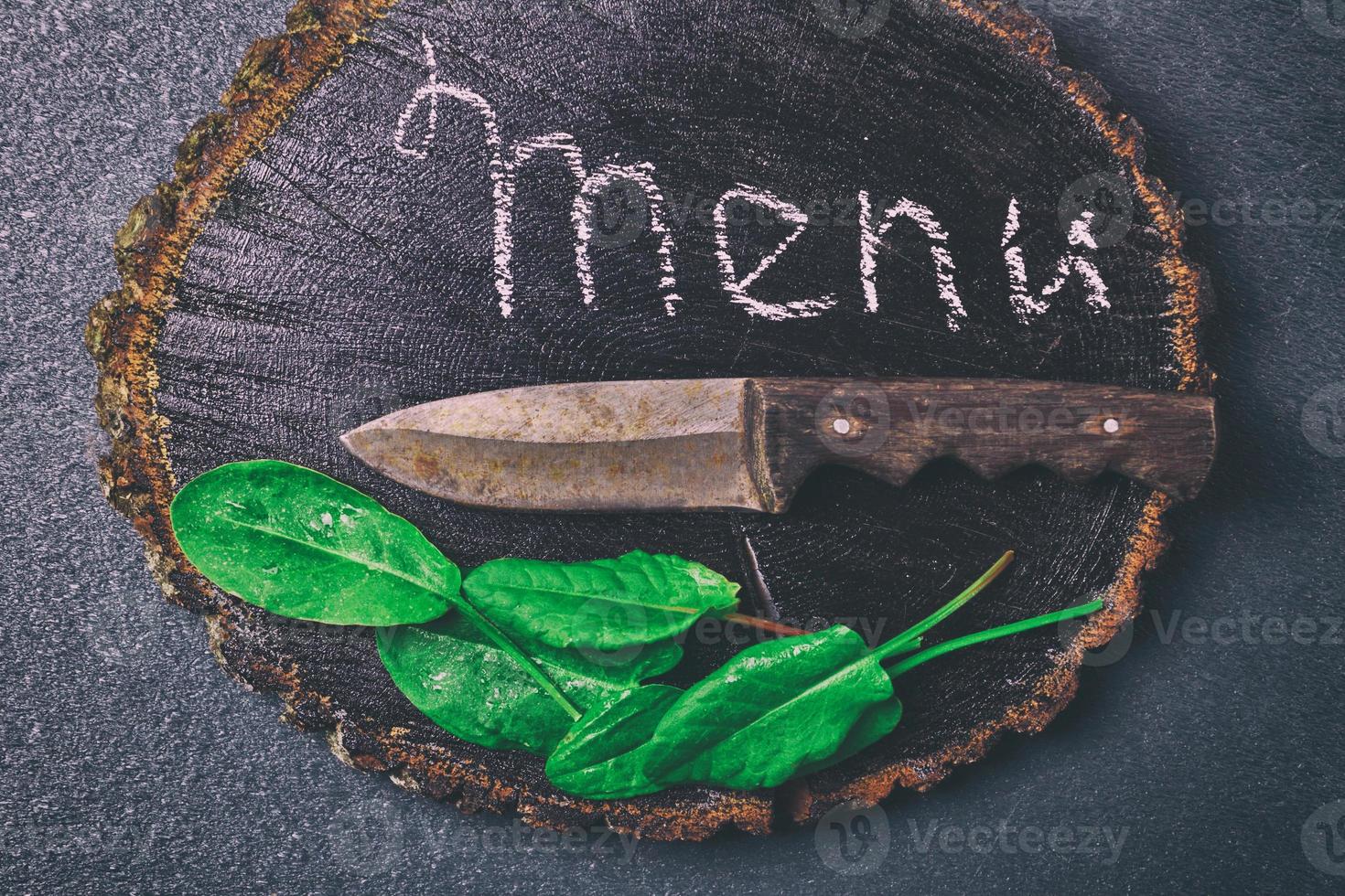 Old kitchen knife lies on a black wooden board photo