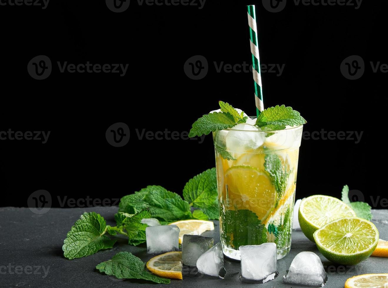 summer refreshing drink lemonade with lemons, mint leaves, ice cubes and lime in a glass photo