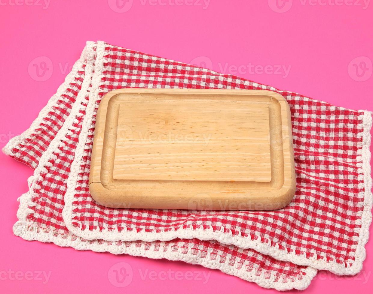 small kitchen wooden cutting board and white red checkered kitchen towel photo