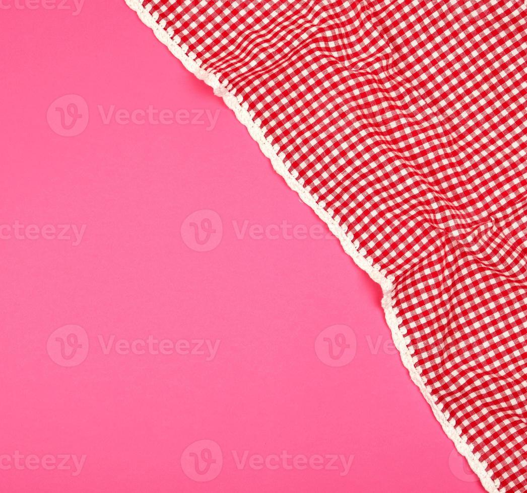 white red checkered kitchen towel on a pink background photo