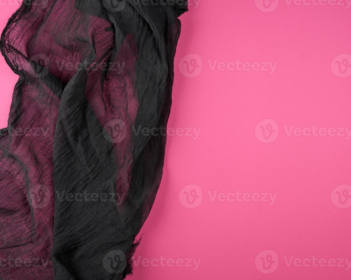 black textile gauze on a pink background photo