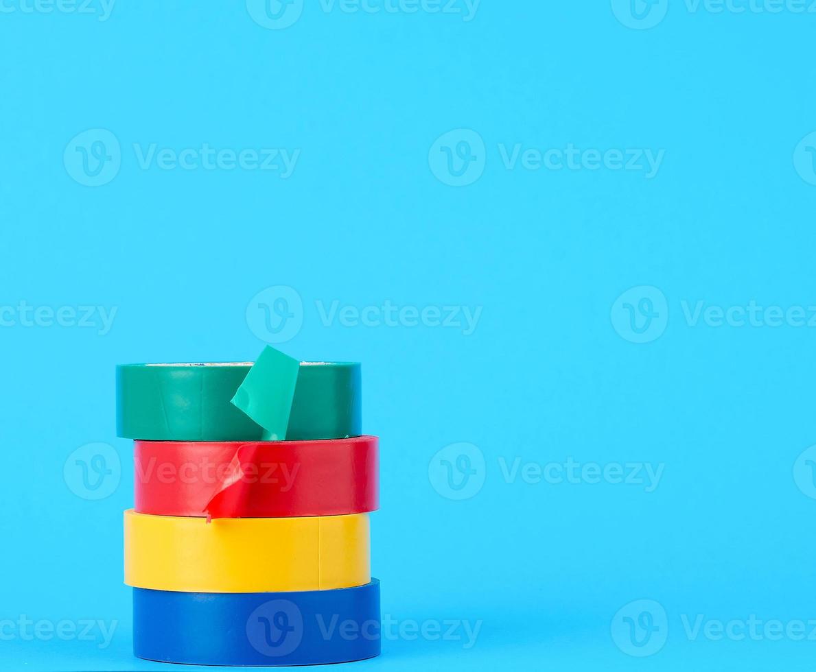 full coils of multi-colored insulating tape on a blue background photo