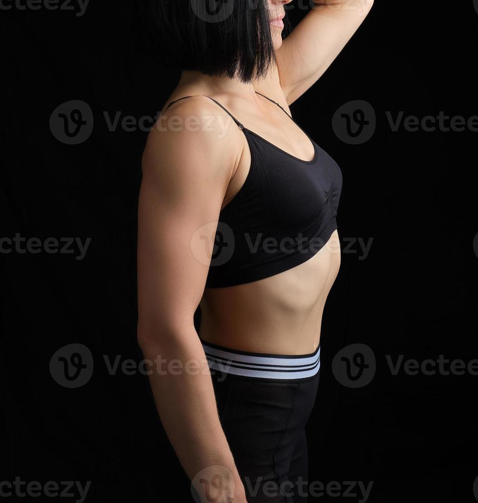 body of a girl of athletic appearance in a black bra and leggings photo