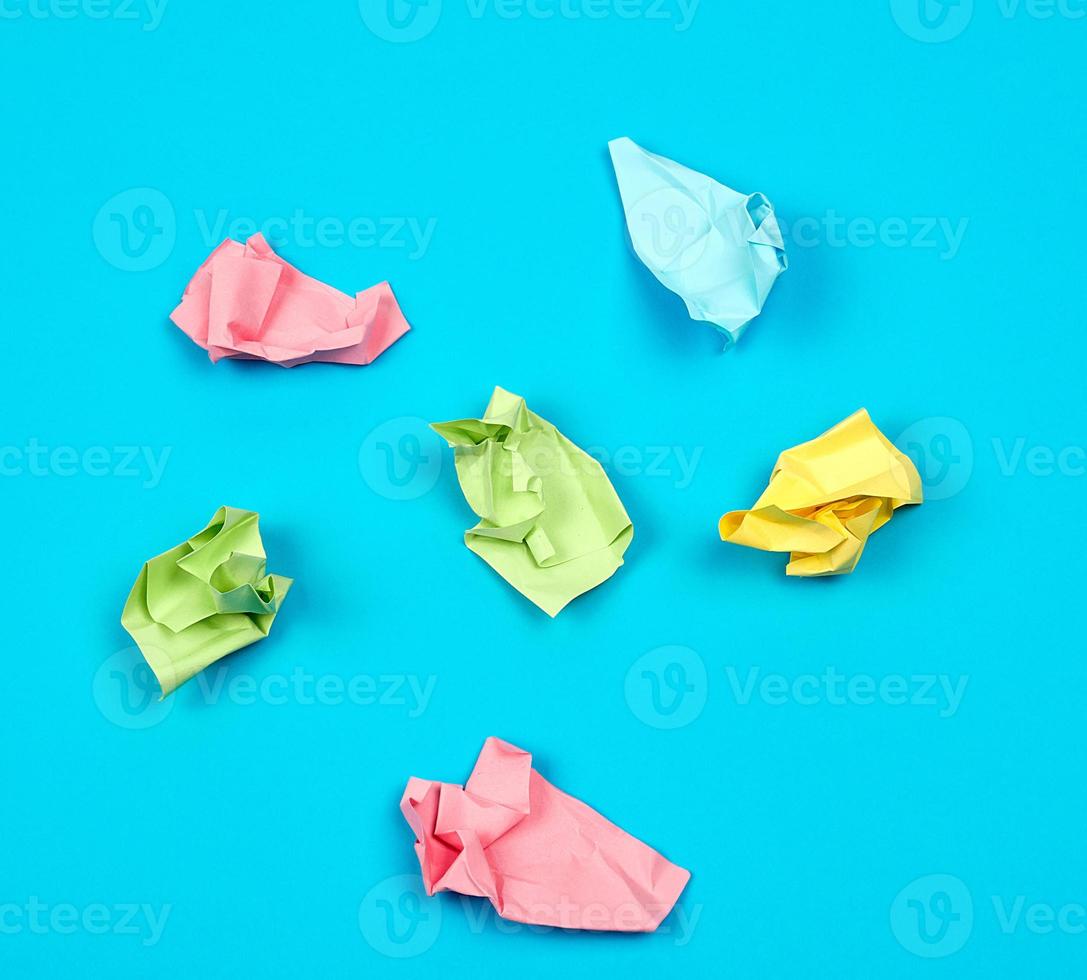 crumpled bright multi-colored paper on a blue background photo