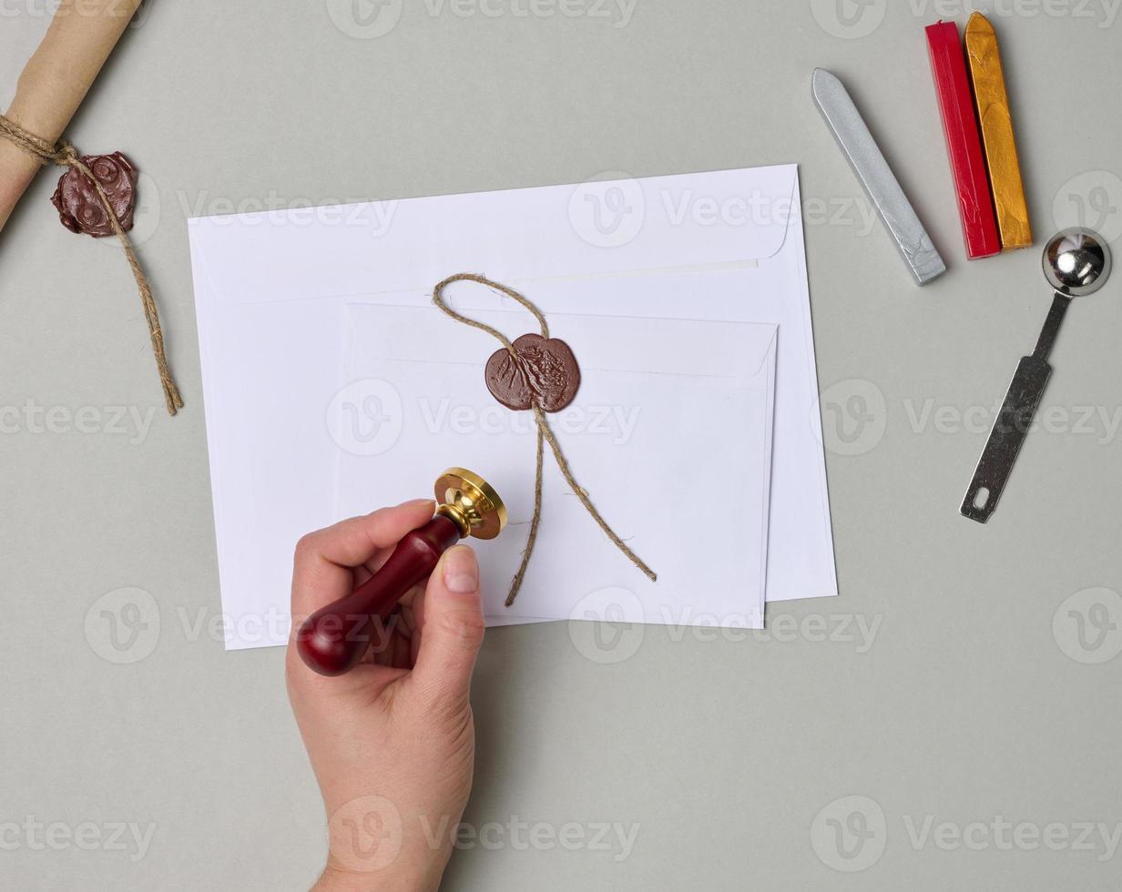sealed white envelope with brown wax seal on beige background, flat lay photo
