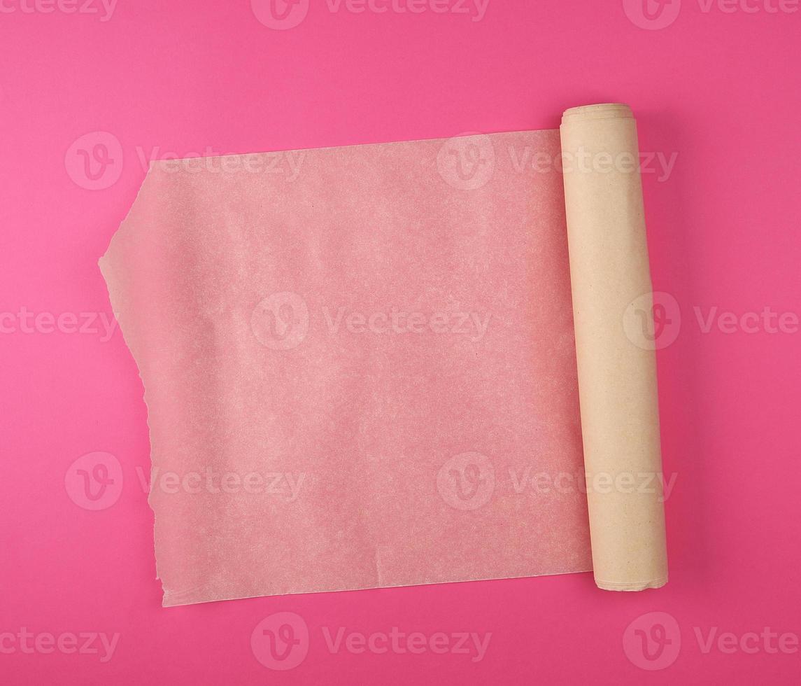rolled brown parchment paper roll for baking on a white background photo