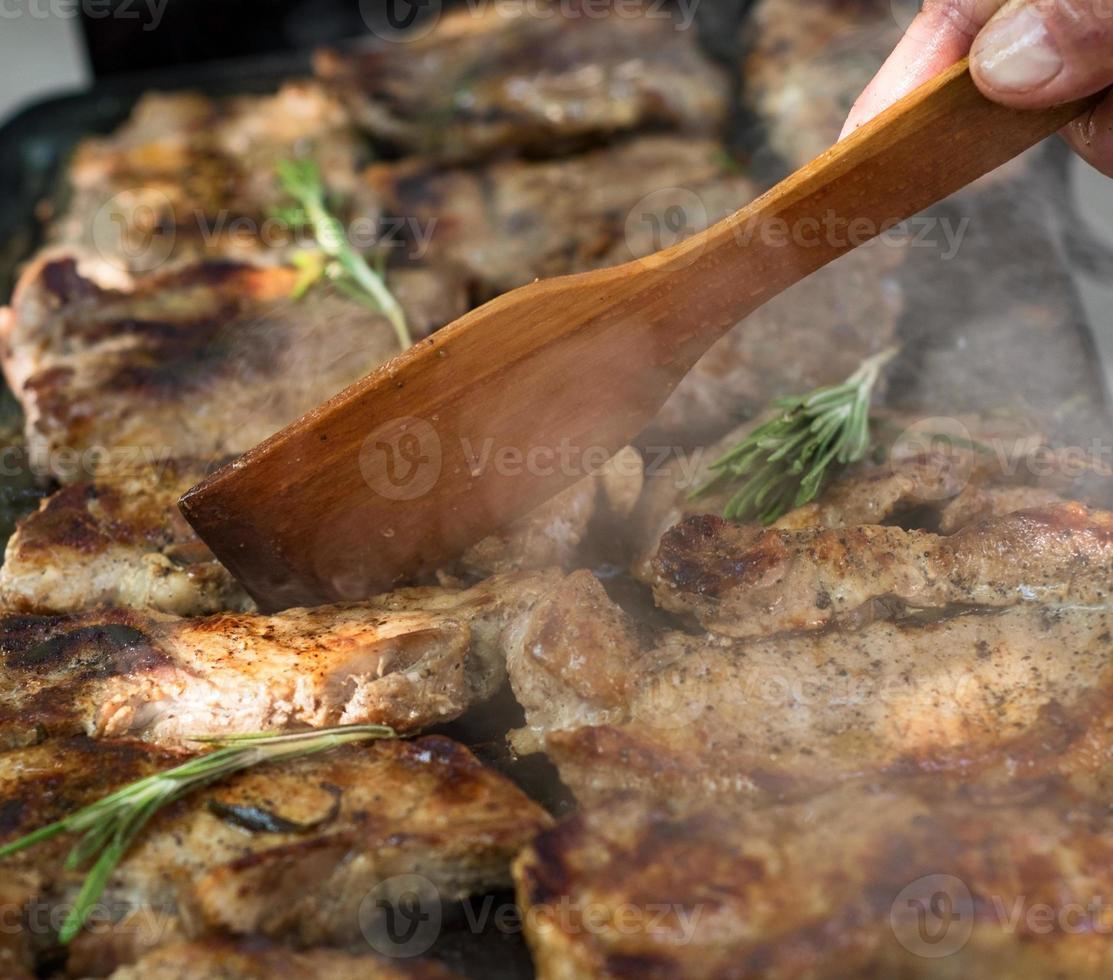 Pork steaks are roasted on a grill photo